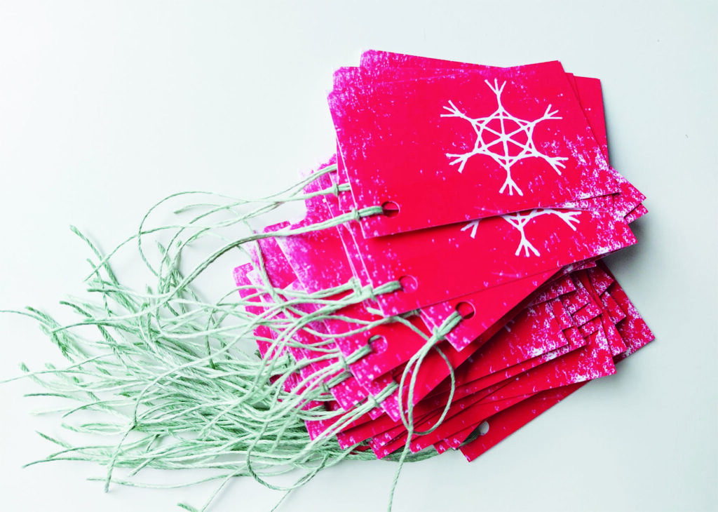 Kleine Anhänger mit weißem Stern auf rotem Hintergrund.